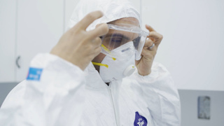 A Lebanese healthcare staff puts on a personal protective mask.