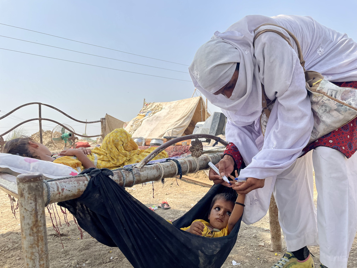 Health worker administering Polio Vaccine to a child during Polio vaccination campaign in Pakistan. 