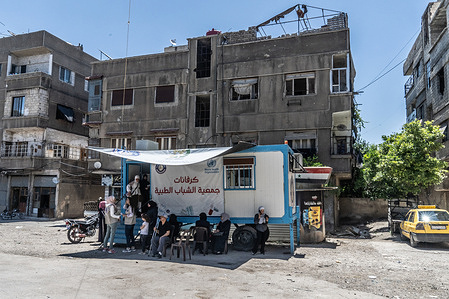 Local residents seeking free healthcare wait outside a WHO-supported Static Medical Point in Saqba, rural Damascus. The Youth Charity Association manages the mobile clinic, which provides health and humanitarian support programs in the rural Damascus region.